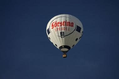 Der hauseigene Heißluftballon, weiß mit roter Aufschrift, vor dunkelblauem Himmel