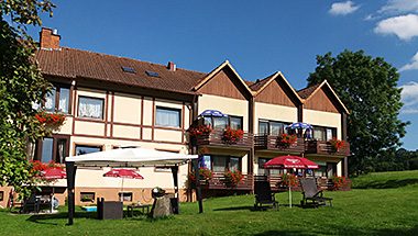 Hotel Luisenhof mit blumengeschmückten Balkonen und Gartenterrasse