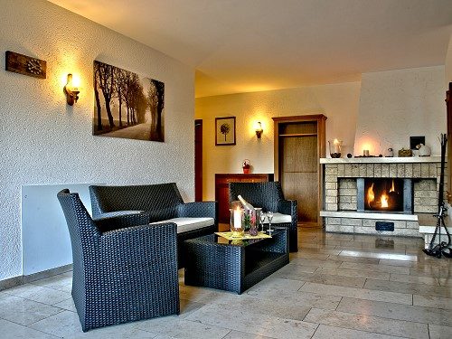 Lounge mit Ledersesseln und Kamin