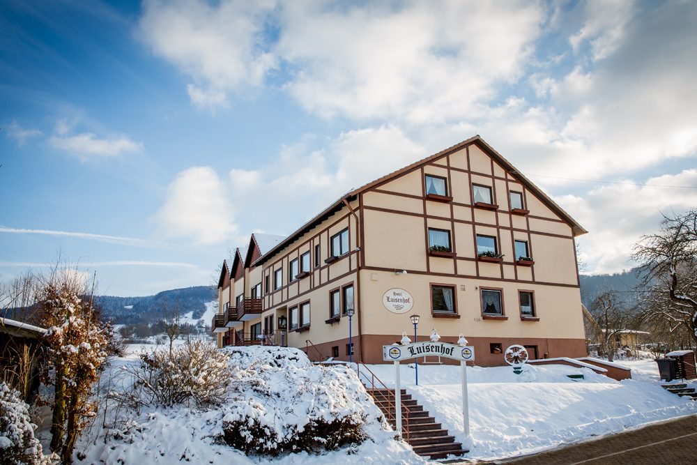 Hotel Luisenhof im Winter mit verschneitem Garten